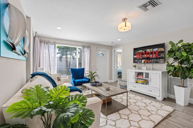 a living room with furniture a chandelier and a window