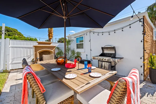 a view of a patio with a table and chairs under an umbrella