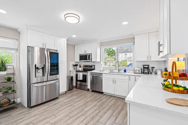 a kitchen with stainless steel appliances granite countertop a sink and a stove