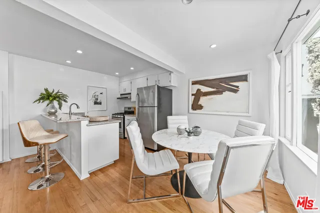 a kitchen with granite countertop white cabinets and chairs