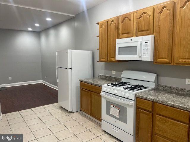 822 North Washington Street, Unit 822 Baltimore, MD 21205 - Photo 11 of 14 a kitchen with a stove a refrigerator and a microwave