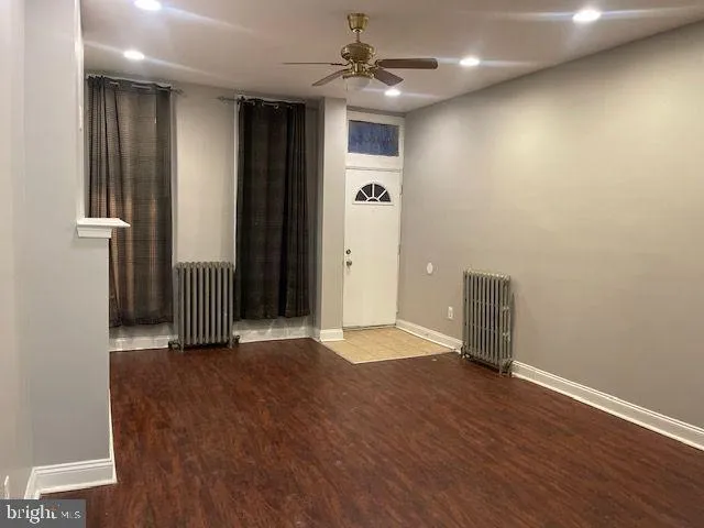 a view of an empty room with wooden floor