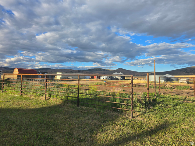 34200 Coulam Road Swan Lake, ID 83281 - Photo 23 of 24 Expansive fenced property with multiple agricultural buildings, mature landscaping, and mountainous surroundings