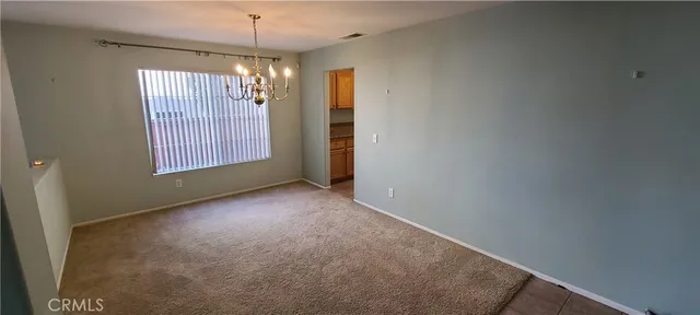 an empty room with windows and chandelier
