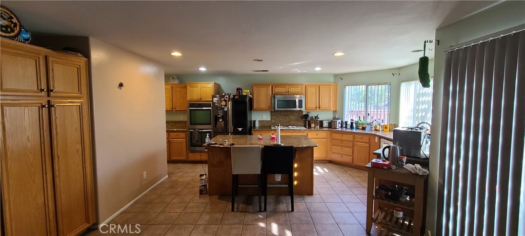 2563 Gilbert Avenue Corona, CA 92881 - Photo 5 of 21 a dining hall with stainless steel appliances a table and chairs