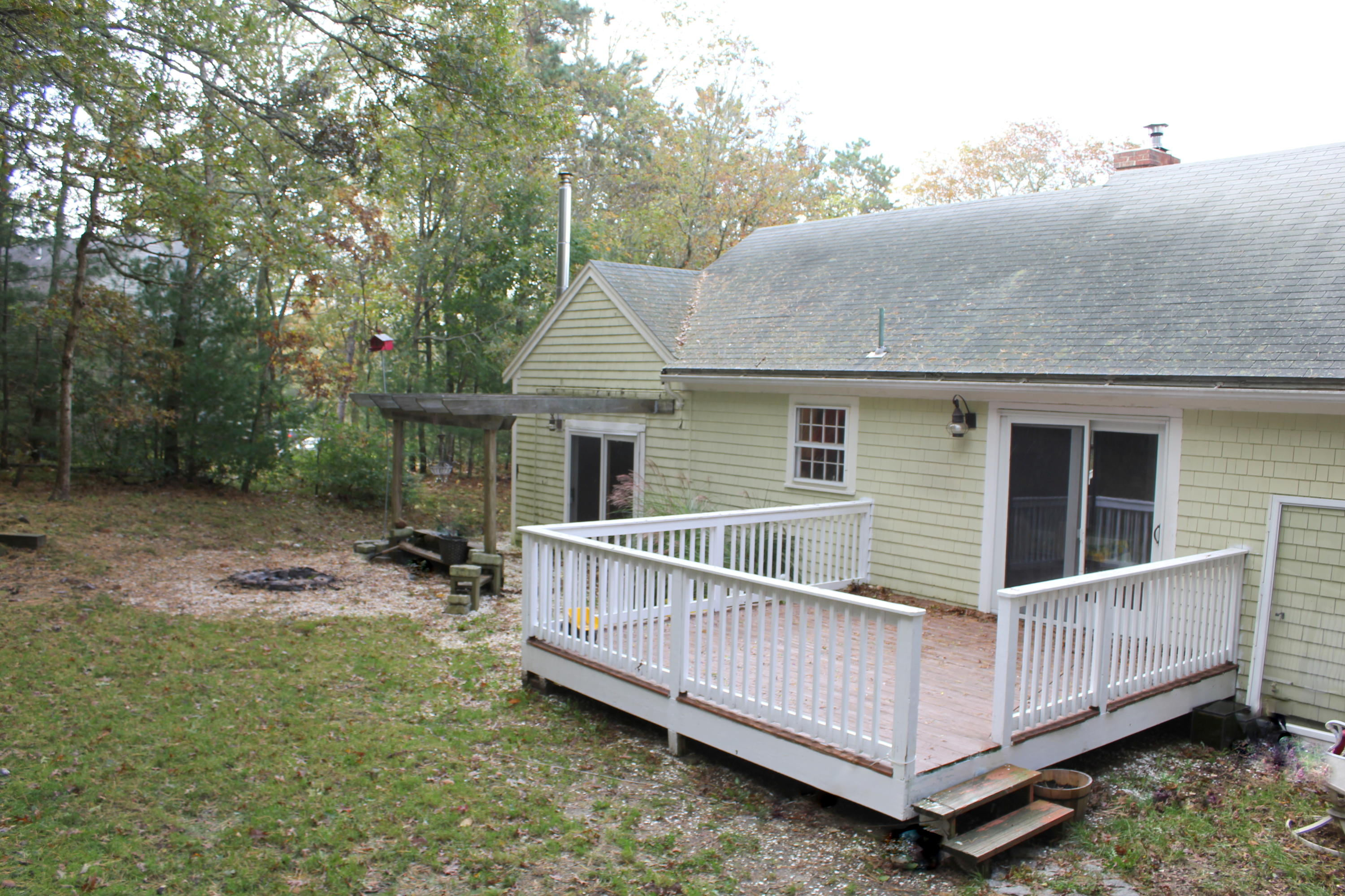 128 Turtleback Road Marstons Mills, MA 02648 - Photo 18 of 20 a view of a house with a yard and wooden fence