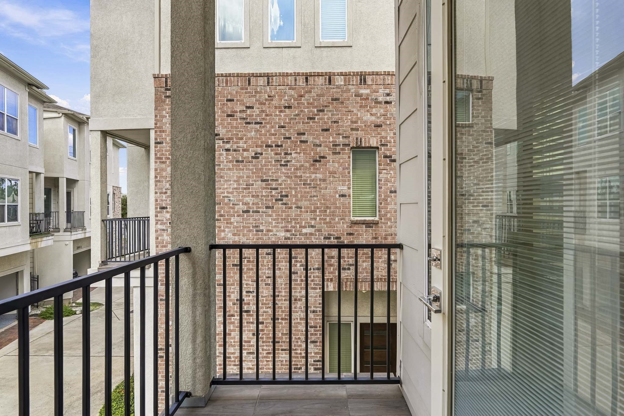 2004 Rosedale Street, Unit D Houston, TX 77004 - Photo 8 of 45 The second-floor balcony features an iron railing and recessed lighting, creating an inviting outdoor space to enjoy fresh air, evening views, or a quiet moment outdoors.