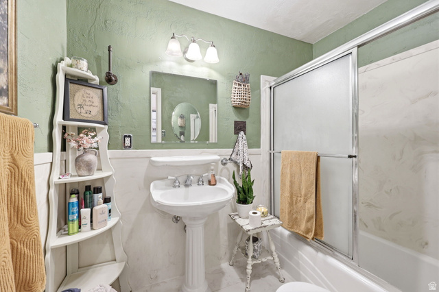 310 South 300 West Payson, UT 84651 - Photo 24 of 42 Bathroom featuring a pedestal sink, white wainscoting, and a shower-tub combination with sliding glass doors