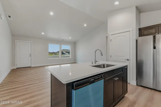 a kitchen with stainless steel appliances granite countertop a sink and dishwasher with wooden floor