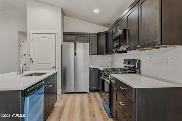 a kitchen with stainless steel appliances a sink stove and refrigerator
