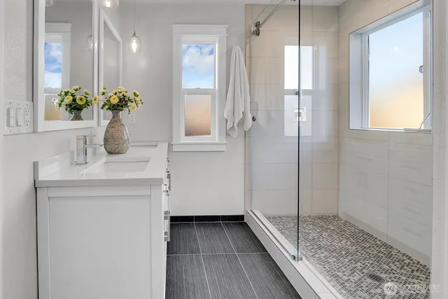 a bathroom with a sink mirror and a shower