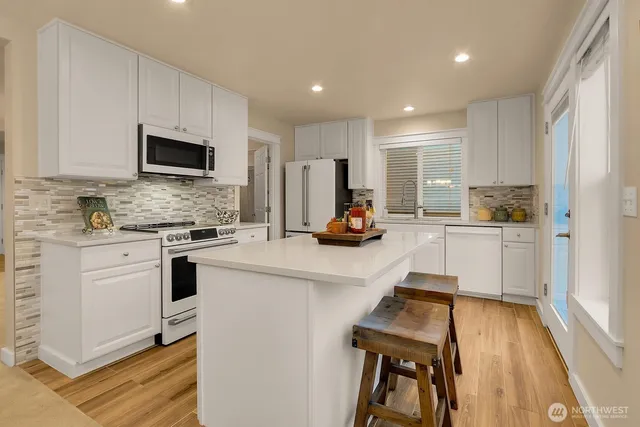 a kitchen with a sink a stove cabinets and a refrigerator