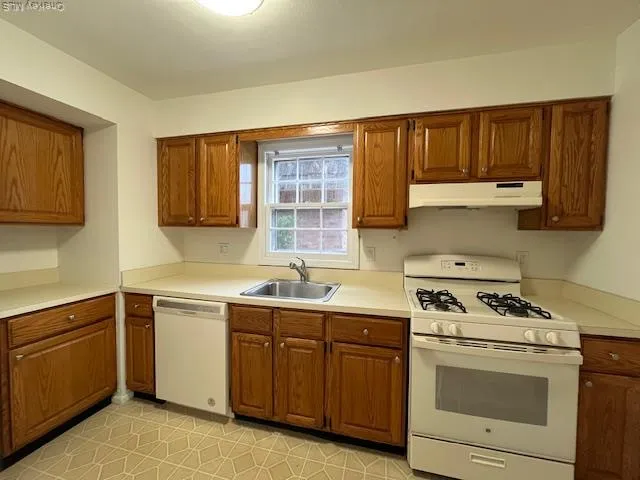 a kitchen with stainless steel appliances granite countertop a stove sink and cabinets