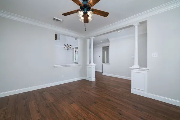 a view of an empty room with window and wooden floor