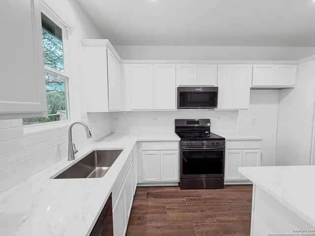 a kitchen with a sink and a stove top oven