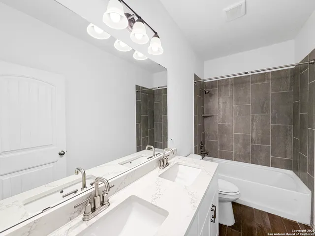 a bathroom with a tub sink and mirror