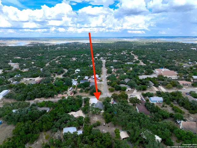 an aerial view of a house with a yard and lake view