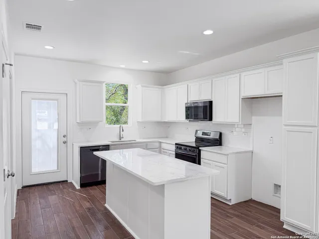a kitchen with a sink a stove a refrigerator and cabinets