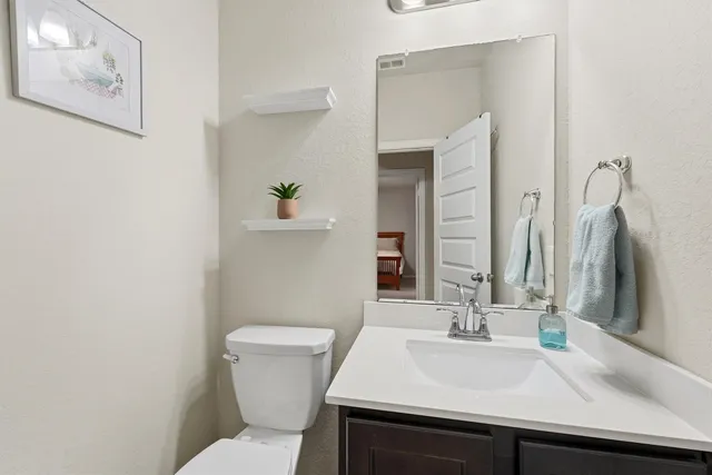a bathroom with a sink a toilet and mirror