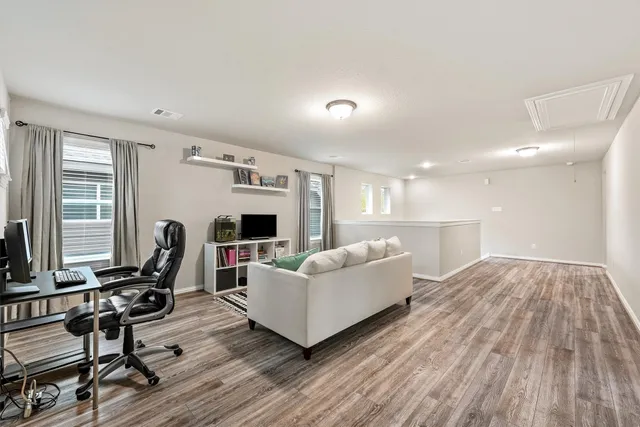 a living room with furniture a wooden floor and a large window