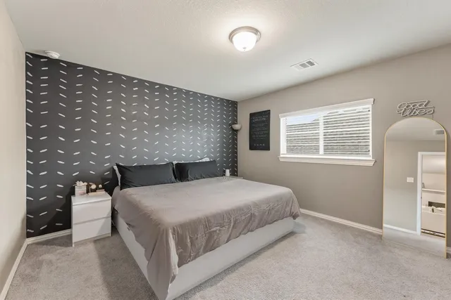 a bedroom with a bed and a night stand