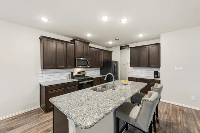 a kitchen with granite countertop kitchen island cabinets and refrigerator