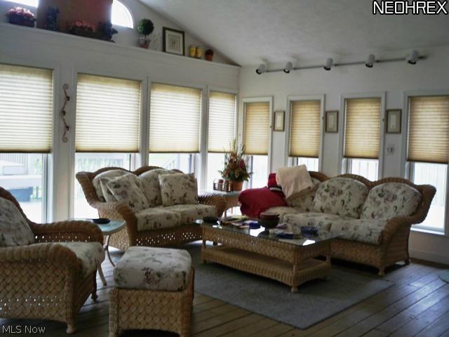 Vaulted 3 season room with wood floor 3 walls of windows 2 exits out to the deck.  add heat and make it a all Season Room