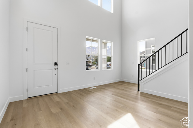 79 South Crimson Way West, Unit 307 Mapleton, UT 84664 - Photo 4 of 42 Soaring ceilings, wood-finish flooring, white walls, multiple windows, and a staircase with black metal balusters