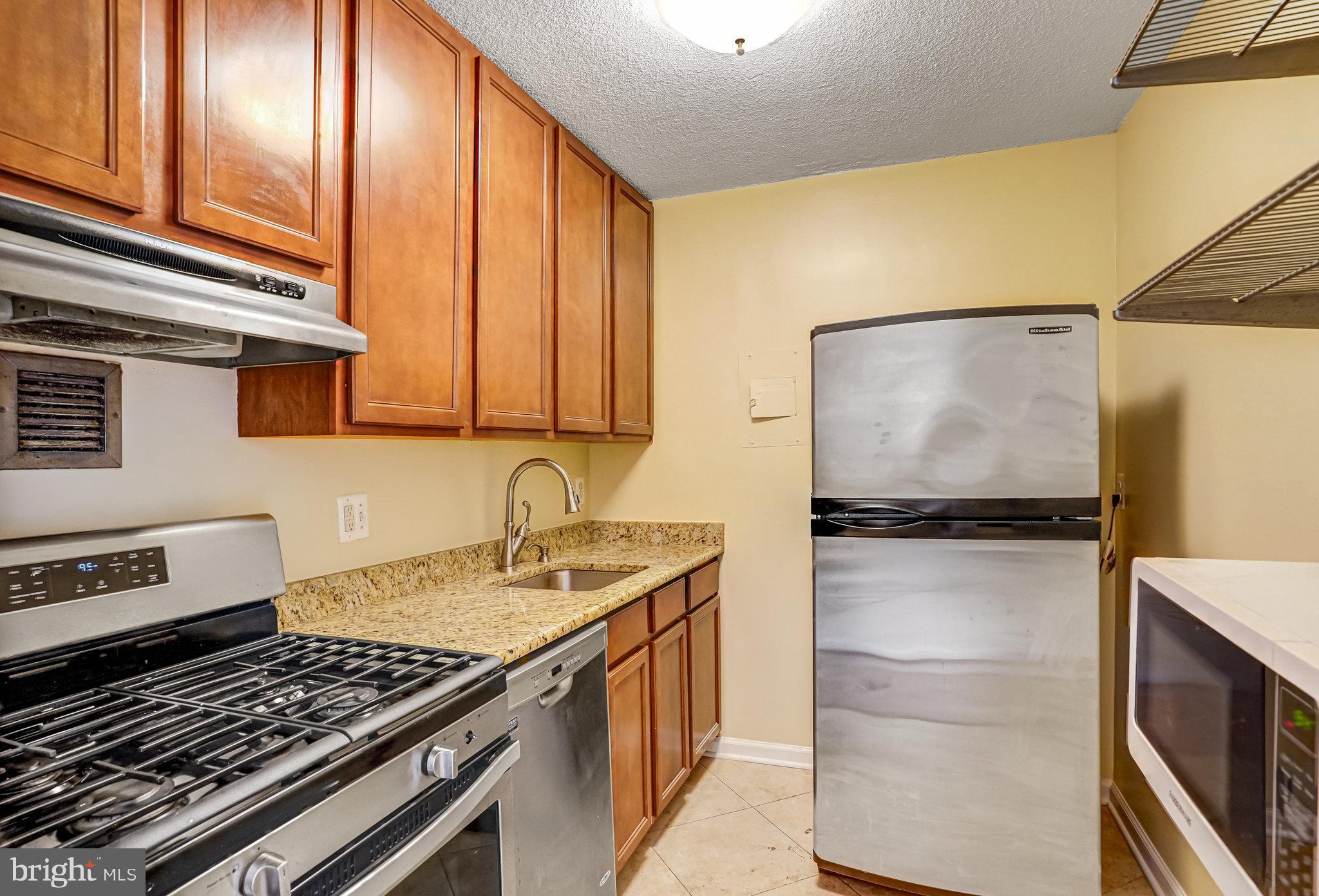1301 20th Street Northwest, Unit 501 Washington, DC 20036 - Photo 12 of 19 a kitchen with a refrigerator stove and sink
