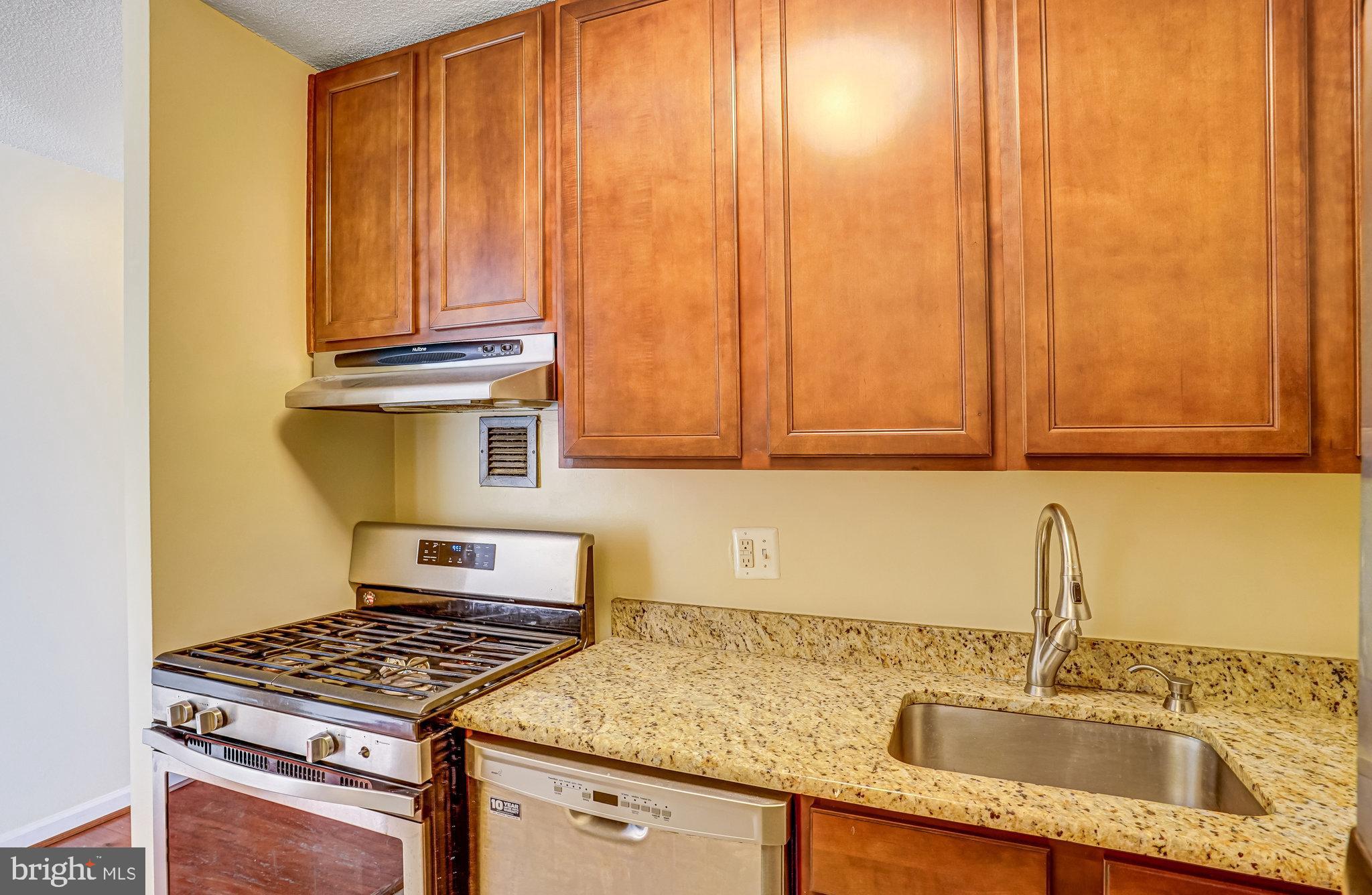1301 20th Street Northwest, Unit 501 Washington, DC 20036 - Photo 14 of 19 a kitchen with granite countertop a sink stove and cabinets