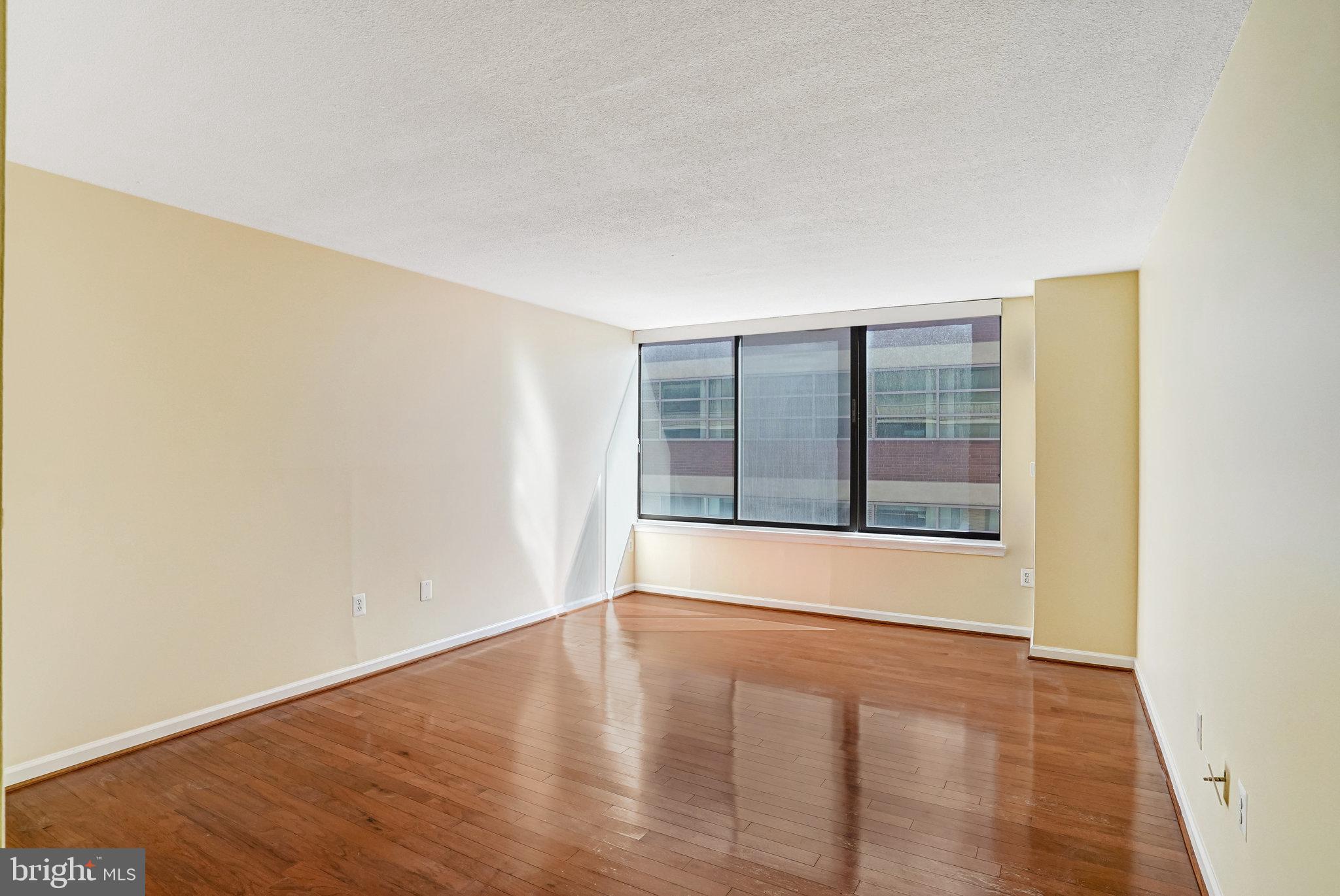 1301 20th Street Northwest, Unit 501 Washington, DC 20036 - Photo 7 of 19 a view of an empty room with wooden floor and a window