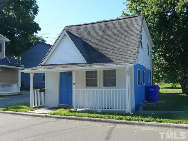 a front view of a house with a garden and plants