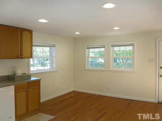 a view of a kitchen with wooden floor and cabinets