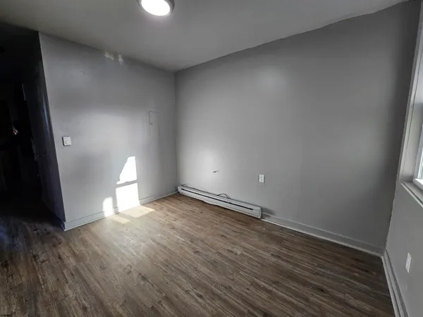 a view of an empty room and wooden floor