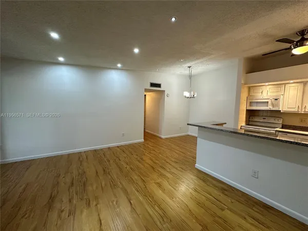 a view of a livingroom with a furniture wooden floor and chandelier