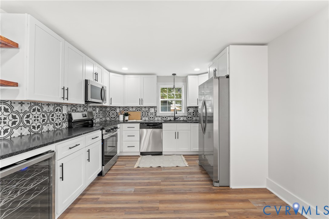 428 3rd Street West Point, VA 23181 - Photo 15 of 49 a large white kitchen with granite countertop a sink and dishwasher a stove with wooden floor