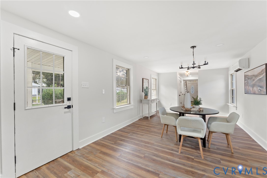 428 3rd Street West Point, VA 23181 - Photo 19 of 49 a dining room with wooden floor a chandelier a wooden table and chairs