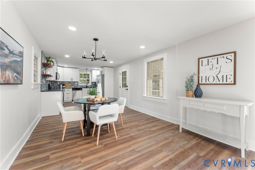 428 3rd Street West Point, VA 23181 - Photo 38 of 49 a dining room with wooden floor a chandelier a wooden table and chairs
