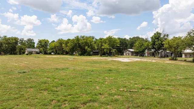 a view of a green field with wooden fence