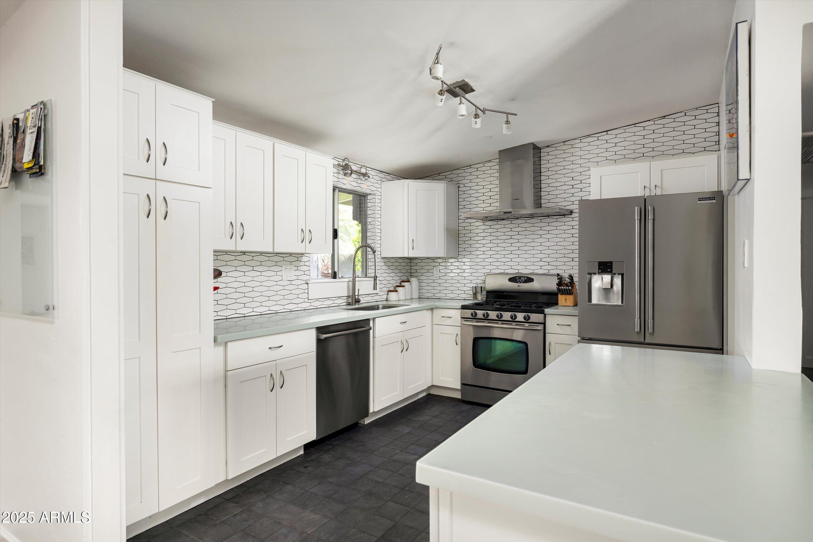 1651 East Rovey Avenue Phoenix, AZ 85016 - Photo 17 of 44 a kitchen with stainless steel appliances granite countertop a refrigerator a sink dishwasher a stove with white cabinets