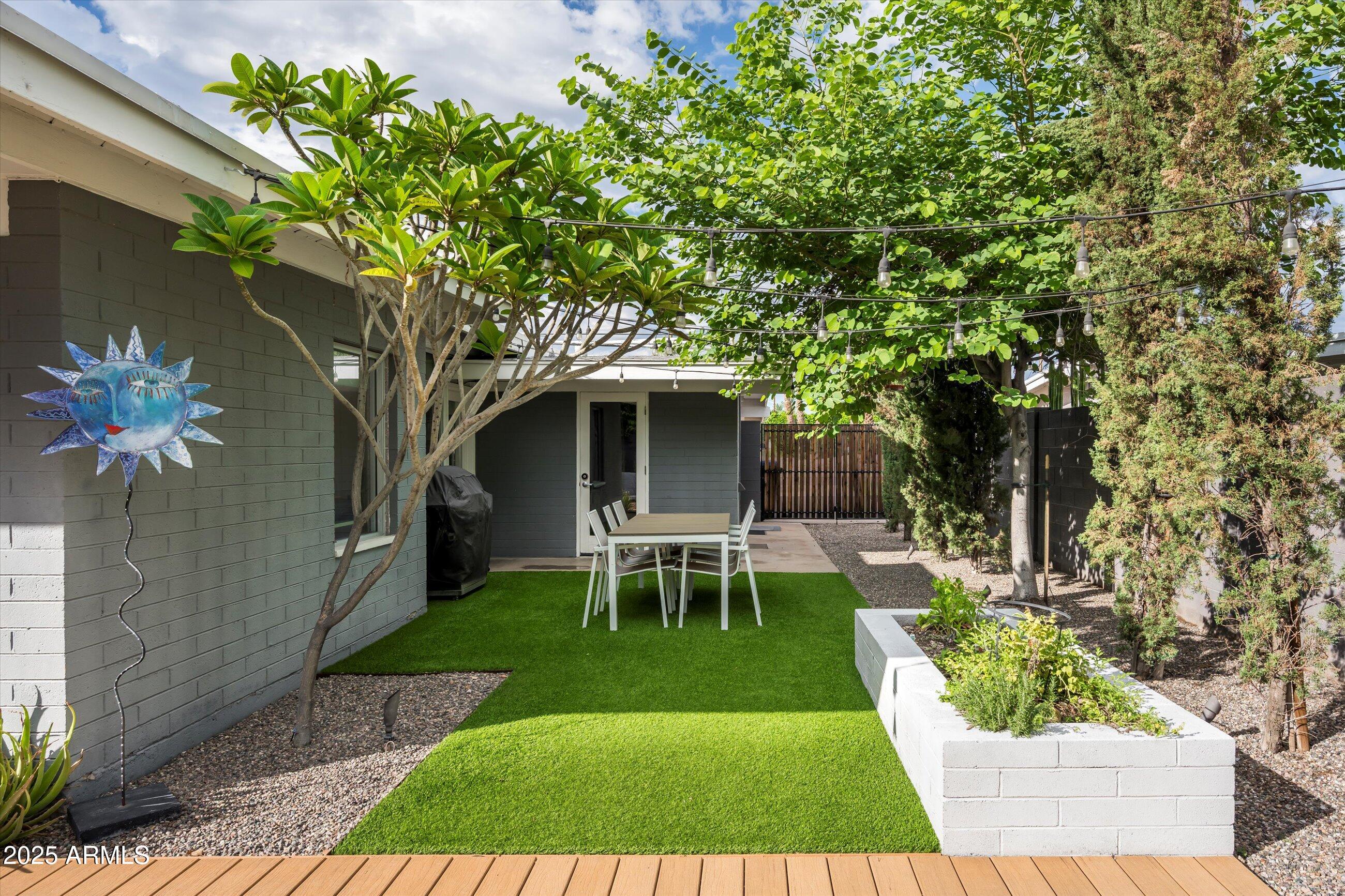 1651 East Rovey Avenue Phoenix, AZ 85016 - Photo 29 of 44 a view of a backyard with table and chairs potted plants and large tree