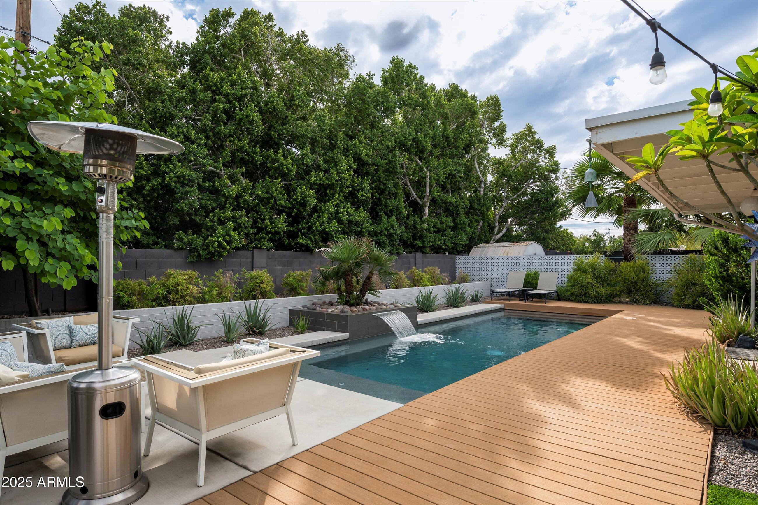 1651 East Rovey Avenue Phoenix, AZ 85016 - Photo 30 of 44 a view of a patio with couches table and chairs with potted plants and large trees