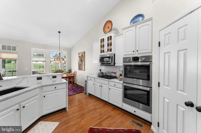 a kitchen with stainless steel appliances a stove cabinets and wooden floor