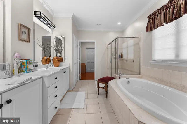 a spacious bathroom with a tub sink double vanity mirror and shower