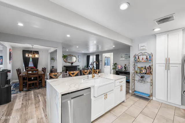 a large kitchen with stainless steel appliances granite countertop a large stove top oven a refrigerator a sink and chairs