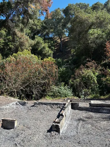 a view of a yard with wooden fence