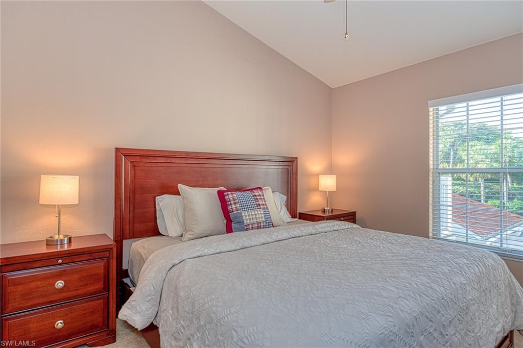 4970 Deerfield Way, Unit F203 Naples, FL 34110 - Photo 15 of 23 a bedroom with a bed and a lamp