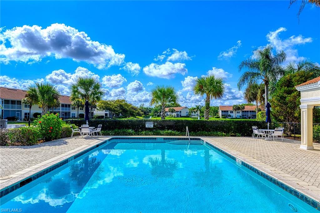 4970 Deerfield Way, Unit F203 Naples, FL 34110 - Photo 21 of 23 a view of a swimming pool with a patio