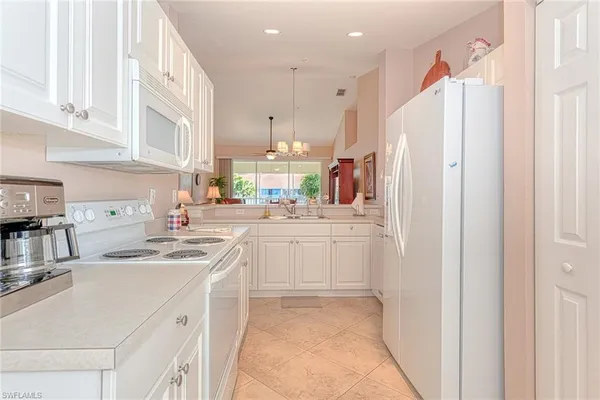 a kitchen with white cabinets and refrigerator