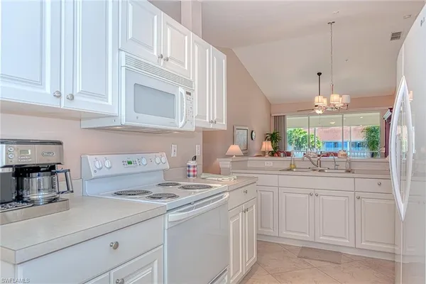 a kitchen with kitchen island granite countertop a sink a stove and cabinets